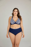 Woman wearing a navy and white striped bikini with a white background