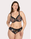 Woman wearing a floral lingerie set on a plain background