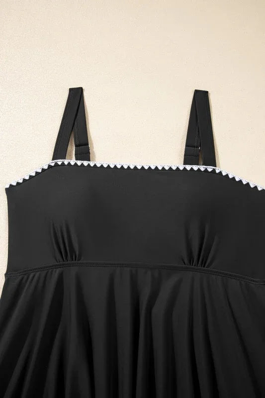 Black plus-size dress with white scalloped trim and adjustable straps, flattering for curves.