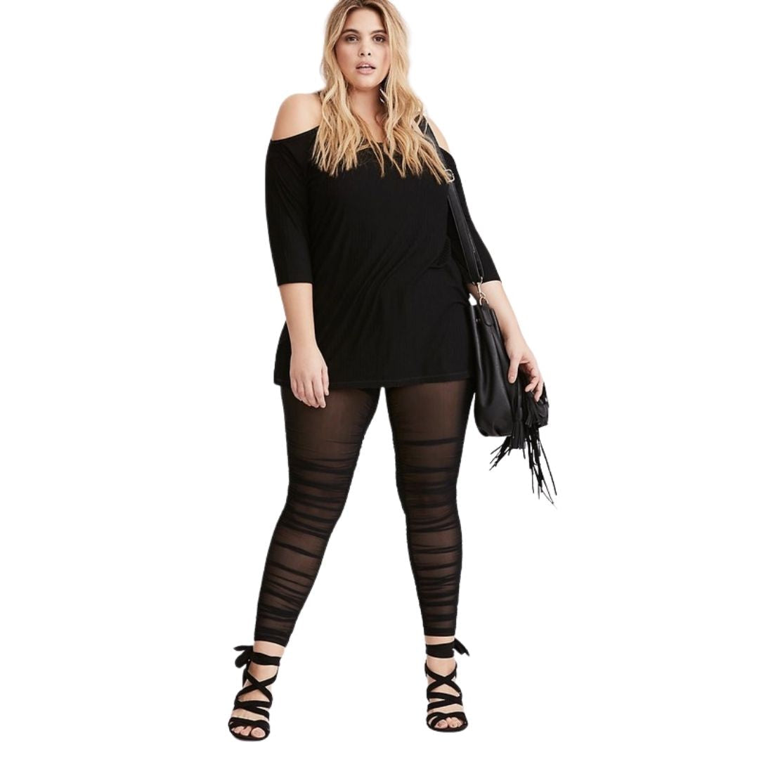 Woman wearing a black outfit with Black Sheer Mesh Ruched Leggings on a white background