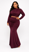 Woman wearing a burgundy long-sleeve dress on a white background