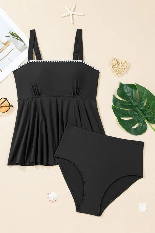 Black peplum swimsuit with white trim, high-waisted bottoms, beach decor
