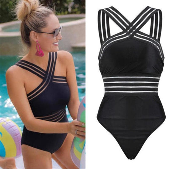Woman wearing a black and white striped swimsuit by a pool
