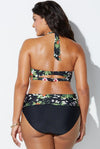 Woman wearing a black floral bikini against a white background